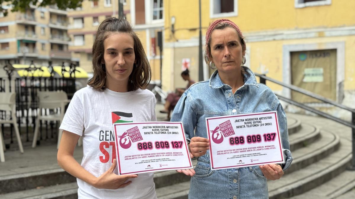 La edil Eva Abuin y la técnica Amets Beltrán de Guevara muestran el teléfono de atención ante los casos de violencia machista.