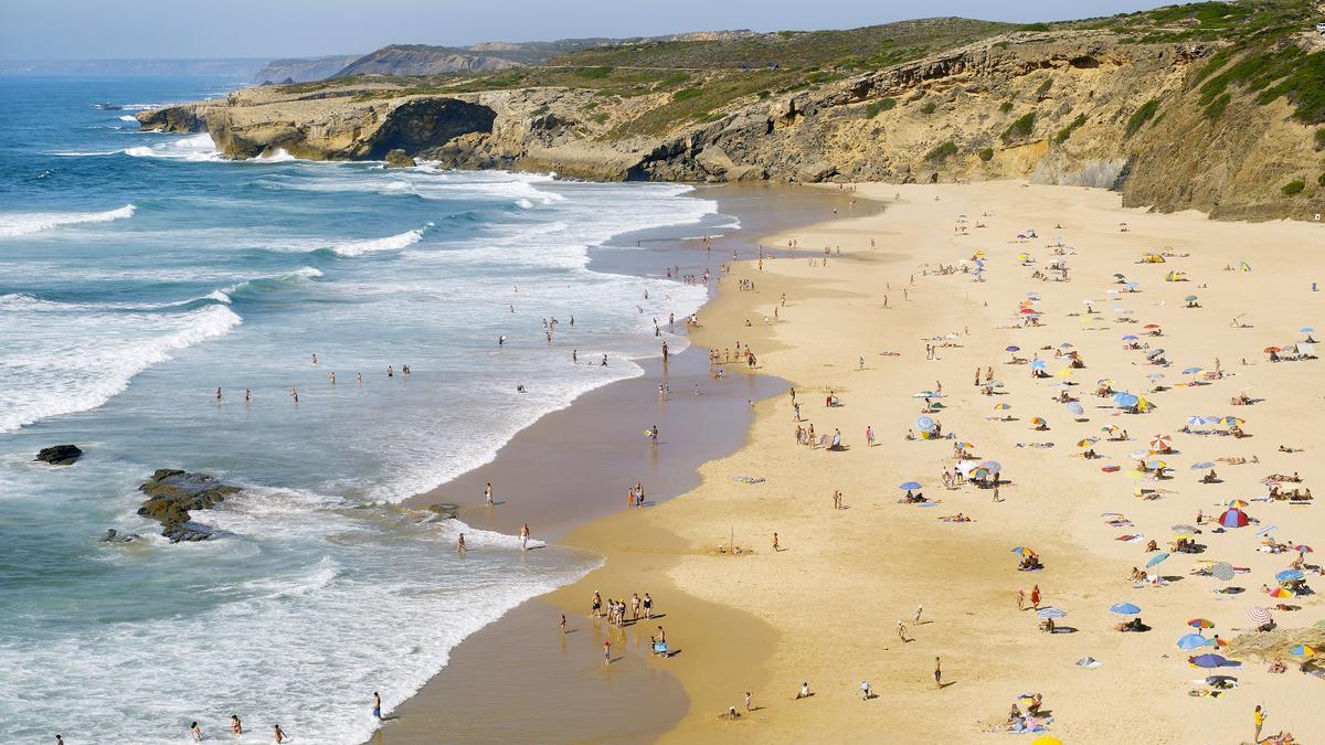 Bañistas en Monte Clérigo, considerada una de las mejores playas de Portugal.