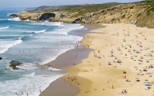Bañistas en Monte Clérigo, considerada una de las mejores playas de Portugal.