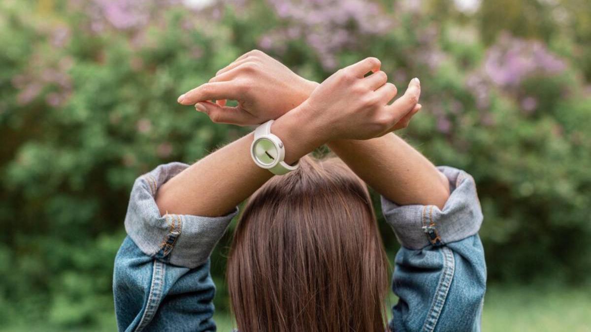 Manos con las manos sobre la cabeza con un reloj en su muñeca