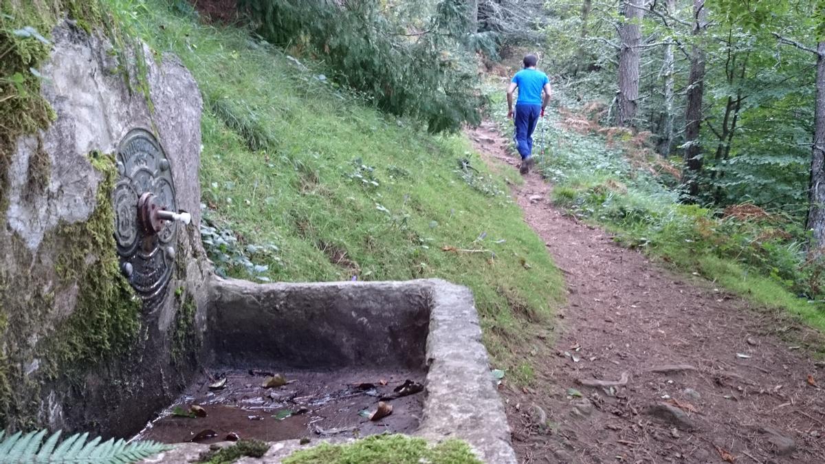 Un montañero se encamina hacia la cima de Karakate tras dejar atrás la fuente.