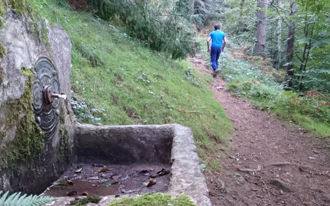 Un montañero se encamina hacia la cima de Karakate tras dejar atrás la fuente.