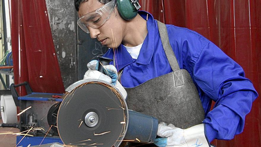 Un joven trabaja en una máquina industrial, uno de los sectores que demandan más mano de obra. | FOTO: E.P.
