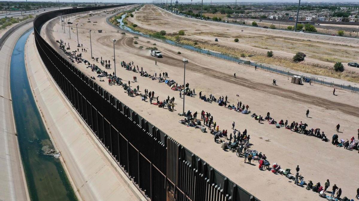 Los migrantes esperan junto a la frontera estadounidense.