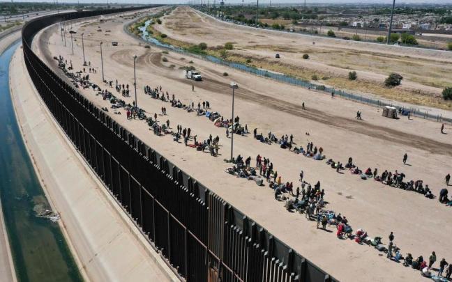 Los migrantes esperan junto a la frontera estadounidense.