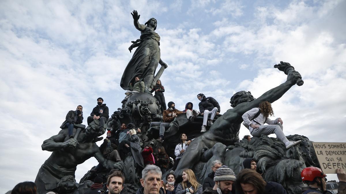 Varios protestantes se suben a la estatua 'El triunfo de la República', en París.