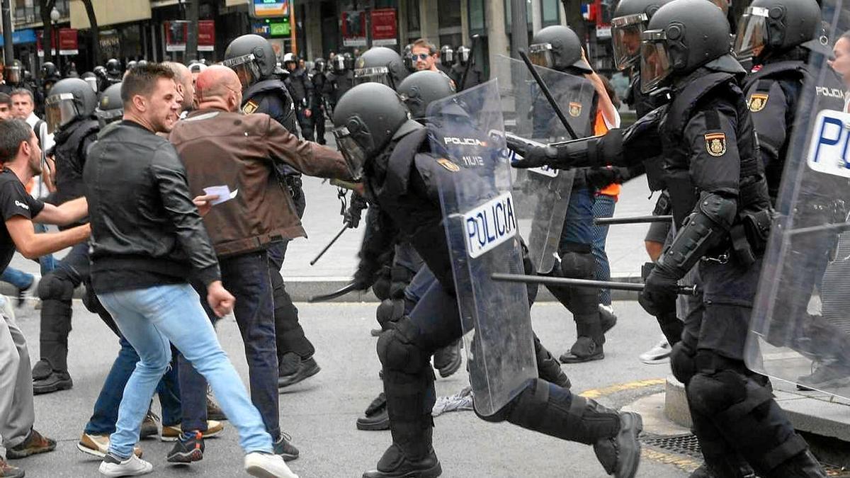 Agentes de la Policía Nacional intentan retirar a los concentrados en el instituto IES Tarragona durante el 1-O. | FOTO: EFE