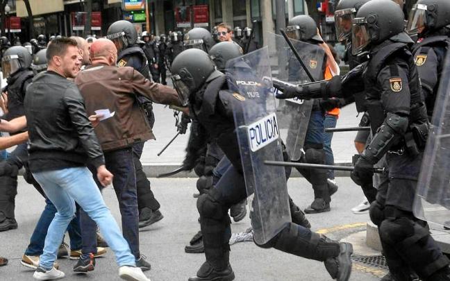 Agentes de la Policía Nacional intentan retirar a los concentrados en el instituto IES Tarragona durante el 1-O. | FOTO: EFE