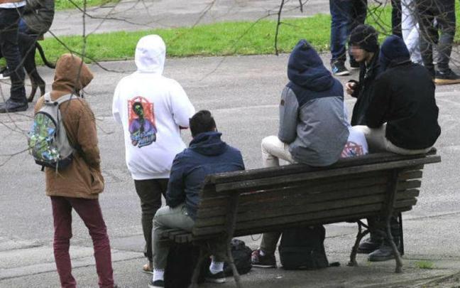 Un grupo de jóvenes, ajenos a la información, en un parque.