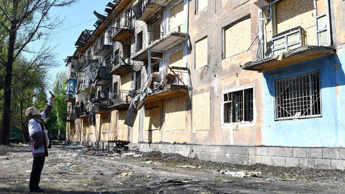 Una mujer saca una foto a un edificio atacado por Rusia en Dobropilia, Ucrania, en una imagen de archivo.