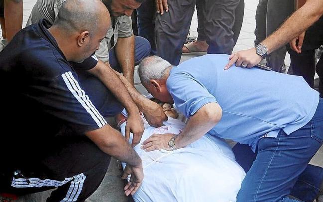 Palestinos lloran la muerte de un gazatí durante un bombardeo israelí el pasado domingo
