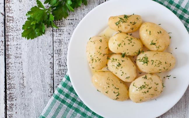 Un plato de patas cocidas con aceite y eneldo.