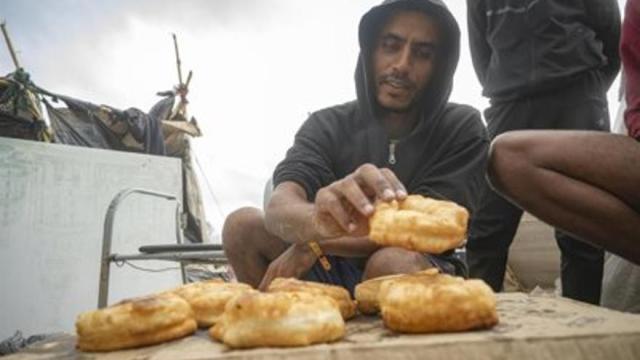 Migrante cocina, en la playa de Trampolín, a 19 de septiembre de 2026, en Ceuta.