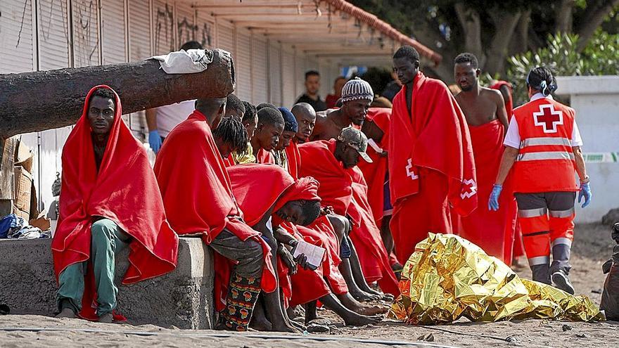 Varios migrantes descansan en la playa de Las Galletas, en Tenerife