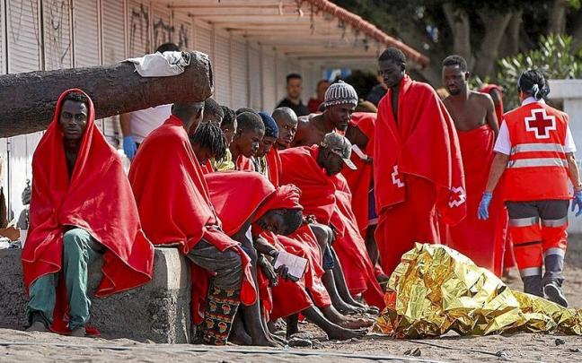 Varios migrantes descansan en la playa de Las Galletas, en Tenerife