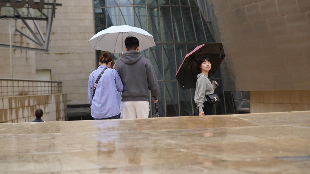 A los turistas les sorprendió la lluvia en el Guggenheim.