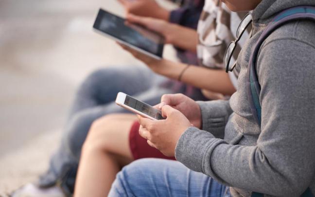 Varios jóvenes con dispositivos electrónicos