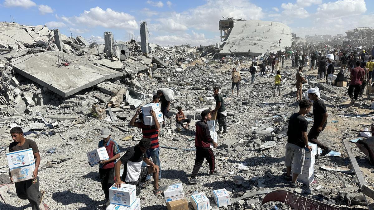 Los gazatíes cargan con cajas de ayuda humanitaria en Jan Yunis.