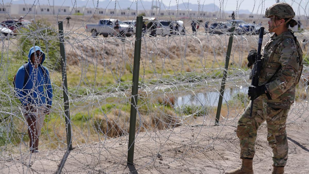 Un miembro de la Patrulla Fronteriza observa a un migrante en la frontera en El Paso, Texas.