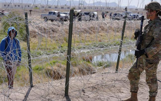 Un miembro de la Patrulla Fronteriza observa a un migrante en la frontera en El Paso, Texas. / EP Un miembro de la Patrulla Fronteriza observa a un migrante en la frontera en El Paso, Texas.