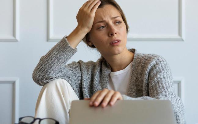 Una mujer estresada en su puesto de trabajo.