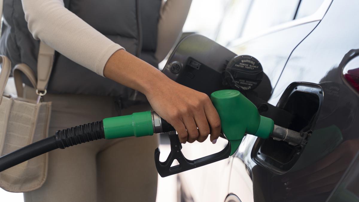 Una mujer, repostando gasolina.