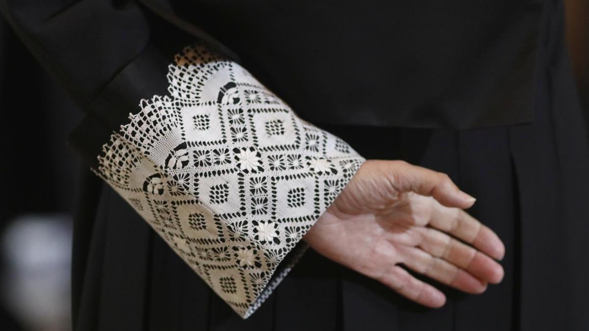 Imagen de la mano de un juez, con la toga negra que visten en las vistas orales.