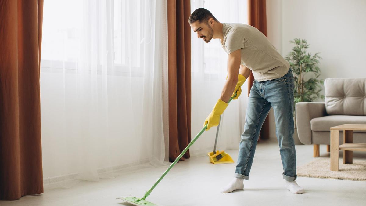 Un hombre pasa la mopa por el suelo
