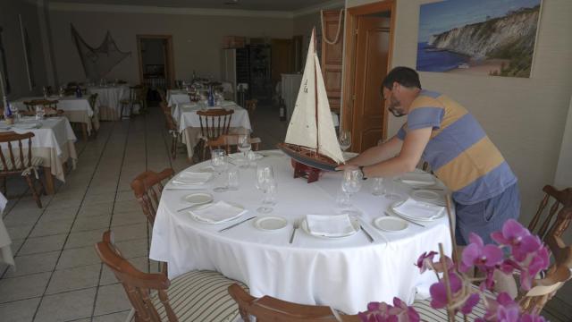 Un hombre prepara una mesa de su restaurante