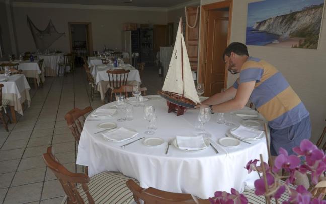 Un hombre prepara una mesa de su restaurante