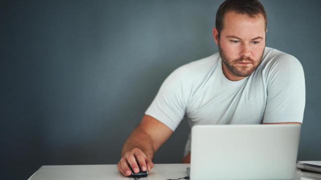Un hombre trabaja frente a un ordenador portátil.