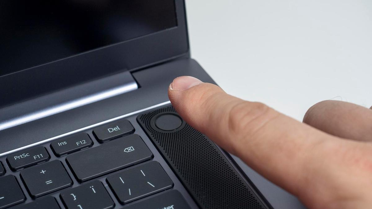 A punto de apretar el botón de encendido de un ordenador portátil.