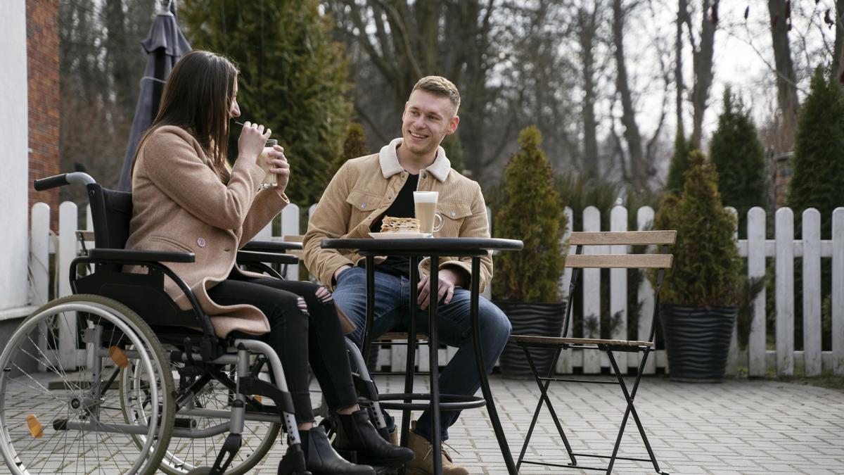 Una pareja toma algo en terraza de un bar.