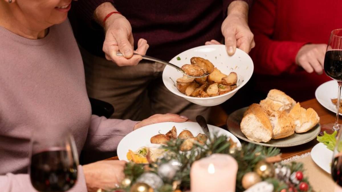 Gente disfrutando de la comida de Navidad en la mesa