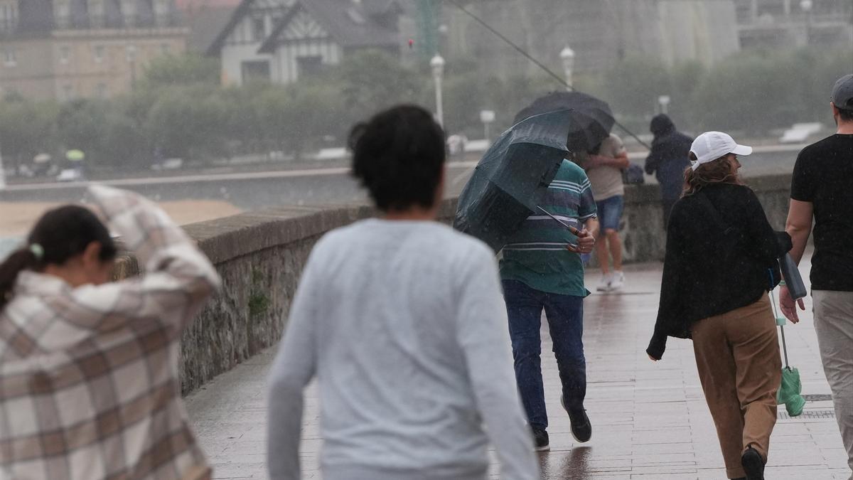 Varias personas caminan bajo la lluvia, en una imagen de archivo.