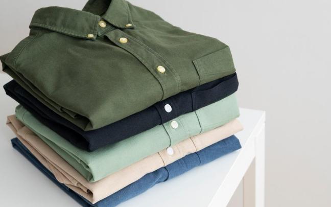 Camisas de caballero apiladas sobre una mesa.