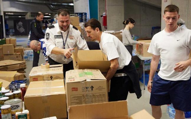 Oyarzabal y Sergio Gómez colaboran en la organización de los alimentos y productos que van a ser enviados a la Comunitat Valenciana. / REAL SOCIEDAD