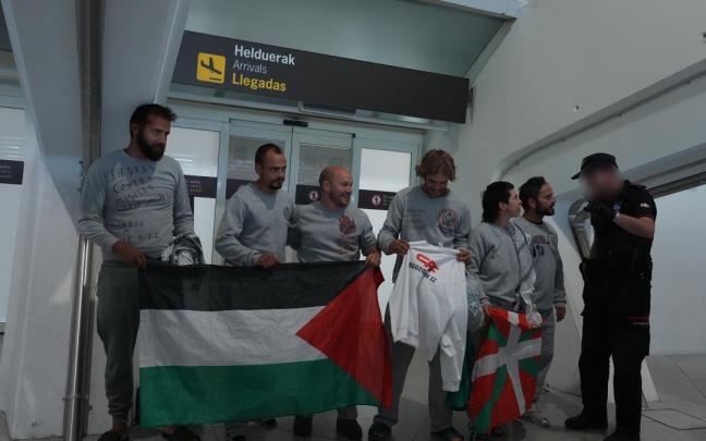 Activistas despliegan una ikurriña y una bandera palestina en el aeropuerto de Loiu.