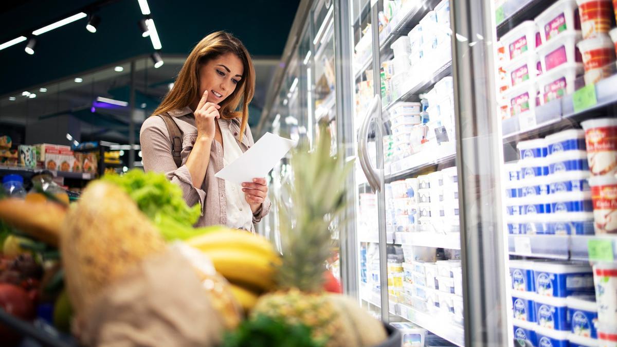 Una mujer sigue la lista de la compra en el súper.