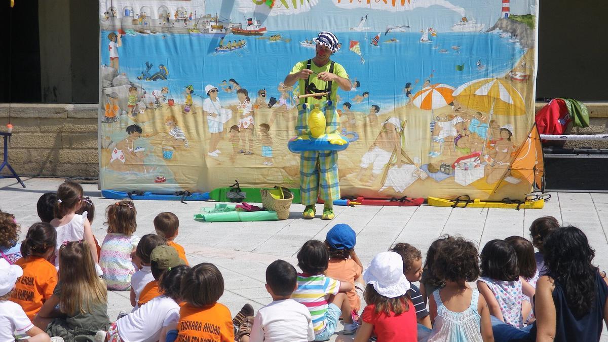 Un grupo de niños disfrutando de un espectáculo en un udaleku.