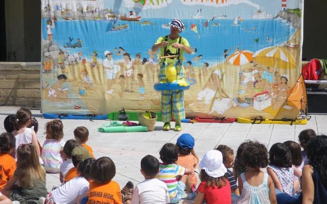 Un grupo de niños disfrutando de un espectáculo en un udaleku.