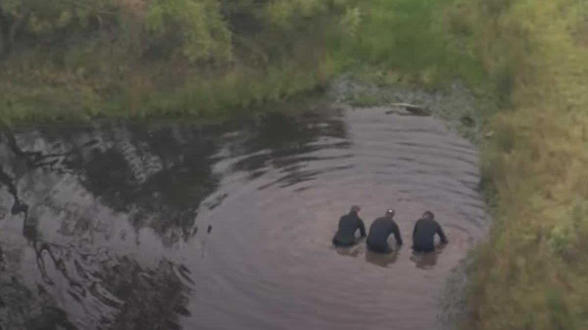 Agentes de policía durante la búsqueda de los cadáveres en un estanque.