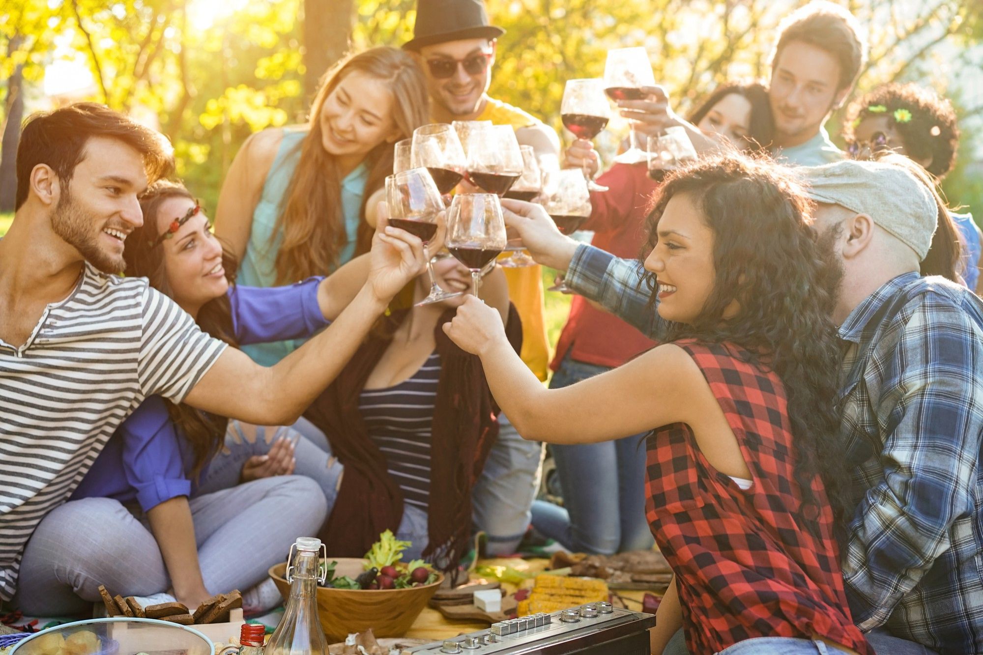 Un grupo de amigos brinda con vino durante una barbacoa.