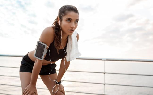 Una mujer se toma un descanso mientras practica running.