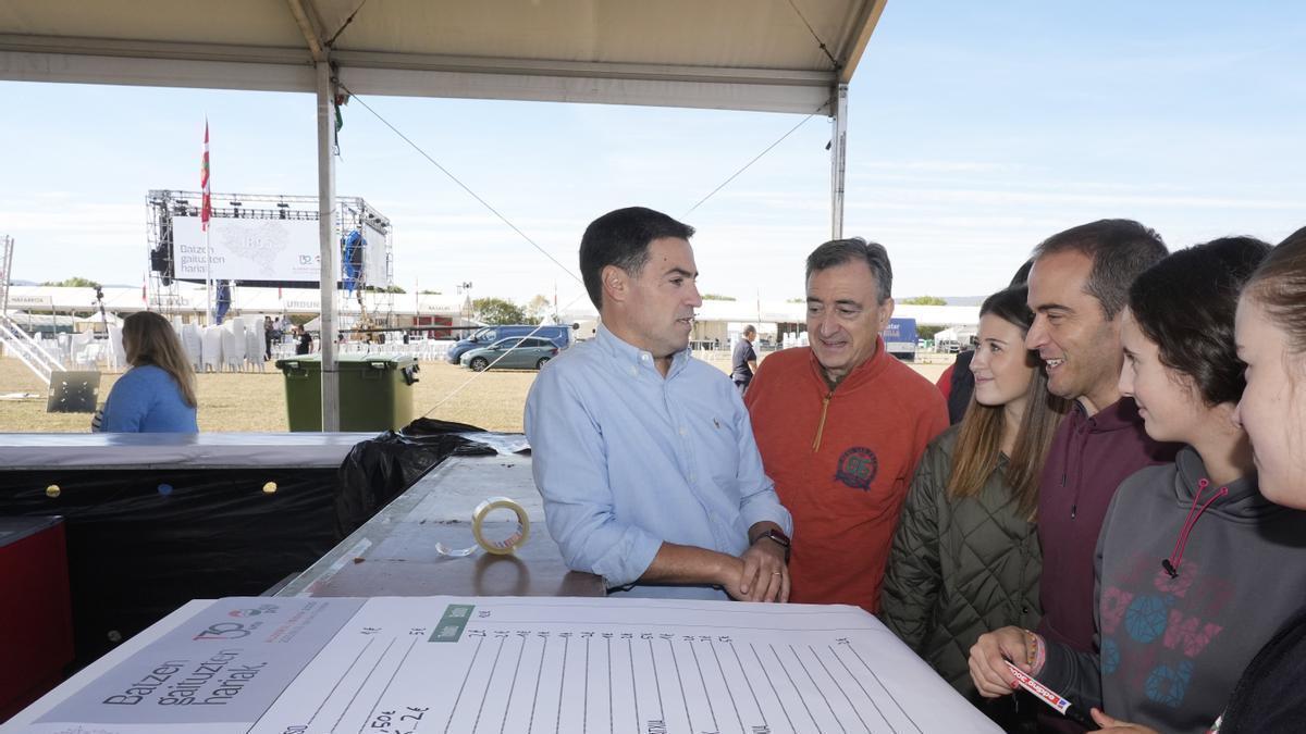 El líder del PNV, Aitor Esteban, y el lehendakari, Imanol Pradales, ayer en las campas de Foronda, junto a un	grupo de voluntarias.