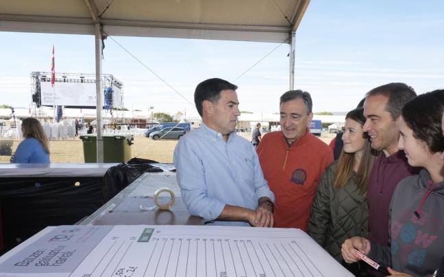 El líder del PNV, Aitor Esteban, y el lehendakari, Imanol Pradales, ayer en las campas de Foronda, junto a un	grupo de voluntarias.