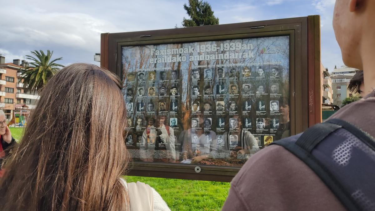 Jóvenes observan un panel con los nombres de las víctimas del franquismo.