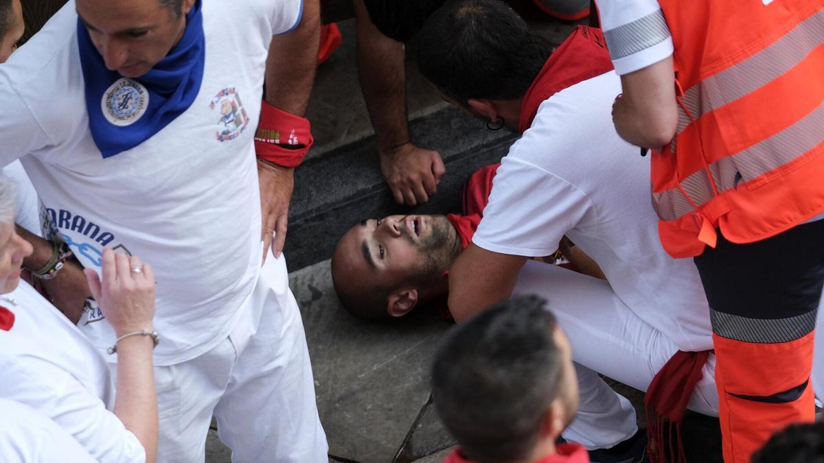 Un corredor herido en el quinto encierro de sanfermines.