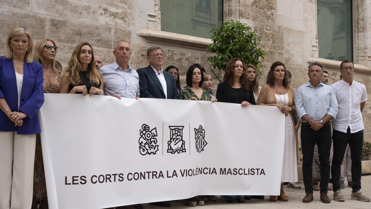 Los diputados de PSOE y Compromís con una pancarta en las Cortes de Valencia.