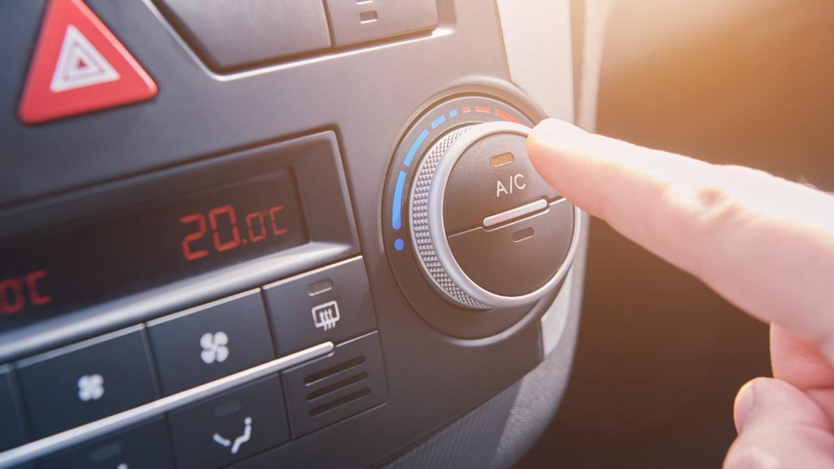 Una persona acciona el sistema de climatización de su vehículo.